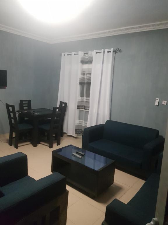 een woonkamer met 2 banken en een tafel bij Superbe appartement in Douala