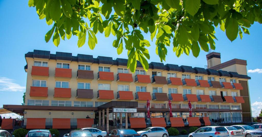 un edificio con coches estacionados frente a él en Hotel Garić, en Garešnica