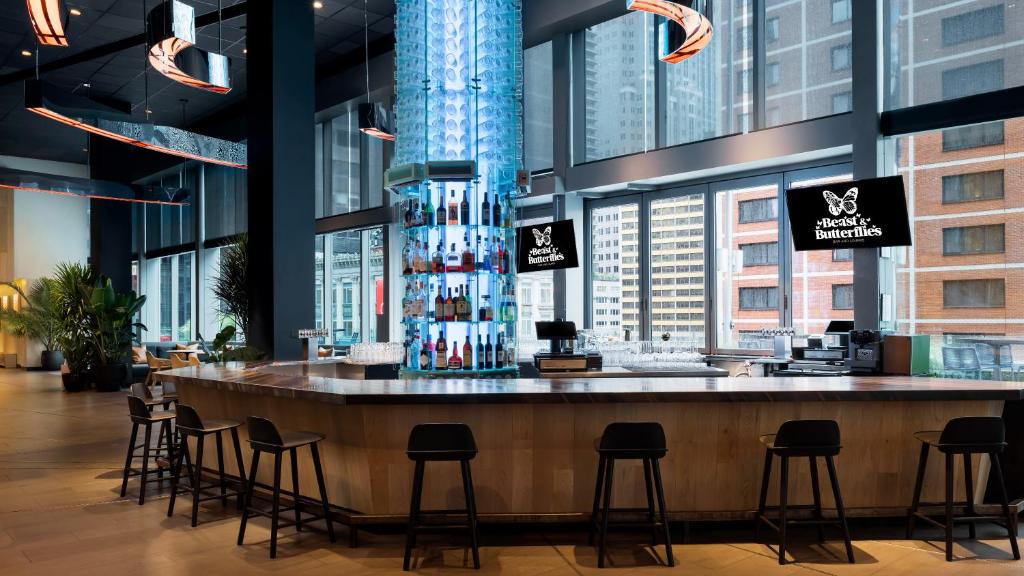 a bar in a building with a bunch of stools at M Social Hotel Times Square New York in New York