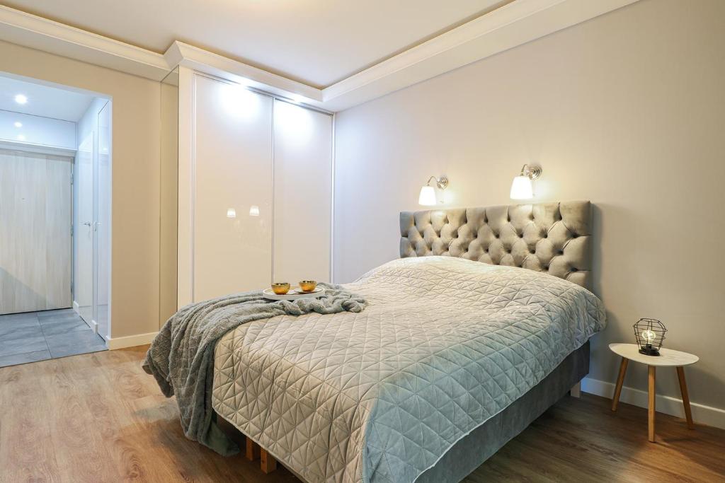 een slaapkamer met een groot bed en een tafel bij Apartament Izabella in Świnoujście