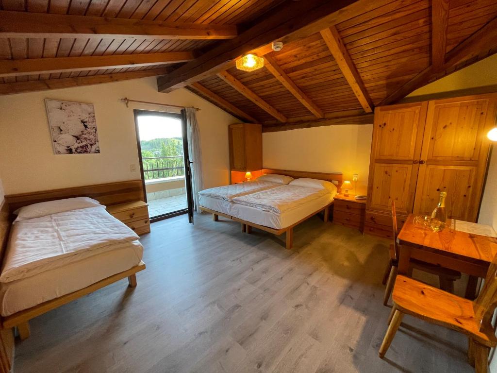 a bedroom with two beds and a desk and a window at Hotel Monte Baldo in Brenzone sul Garda