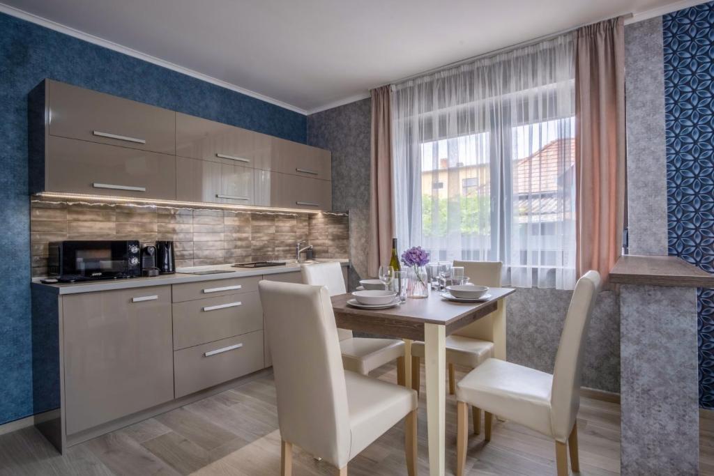 kuchnia z drewnianym stołem i krzesłami oraz jadalnia w obiekcie MyFlat Premium Resort w Siófoku