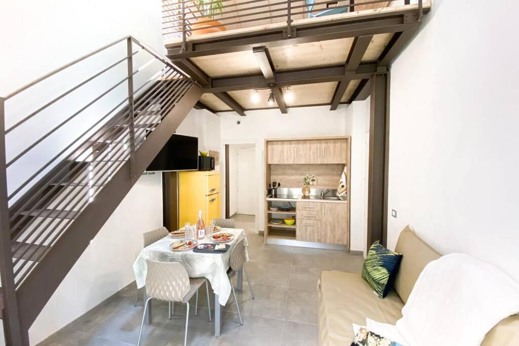salon ze stołem i schodami w obiekcie New Agriloft 4 Palms clima, giardino e Wi-Fi a 50 mt dal mare w mieście Bordighera