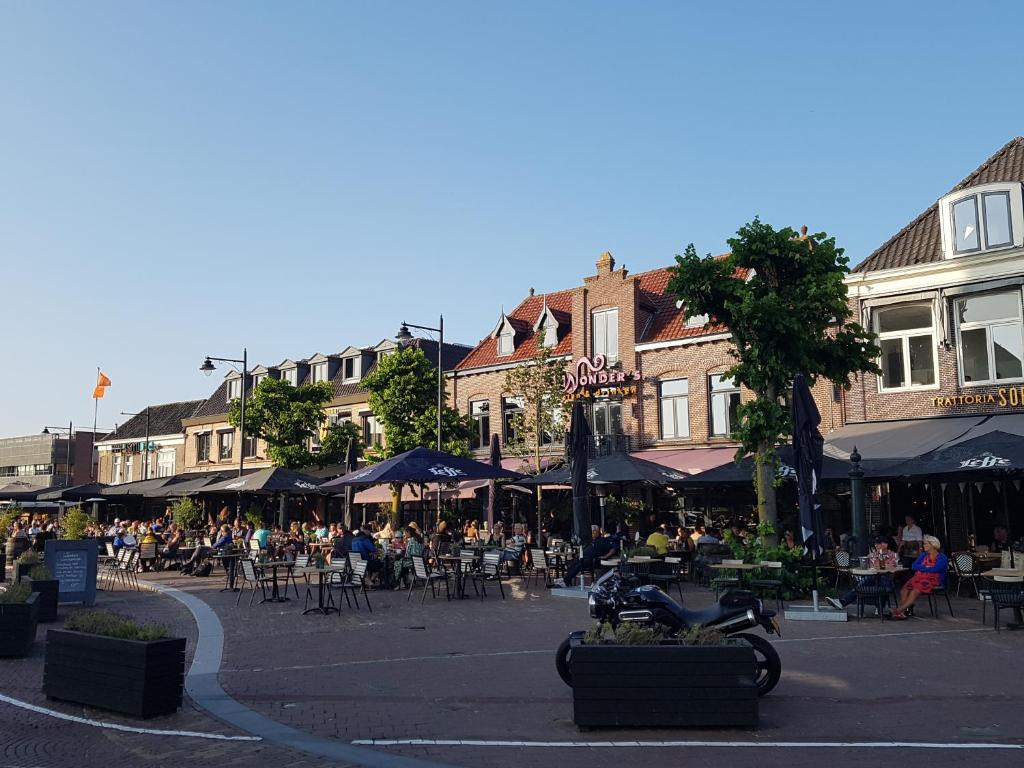 een groep mensen die aan tafel zitten in een stadsstraat bij Bed & Breakfast Moments in Schagen