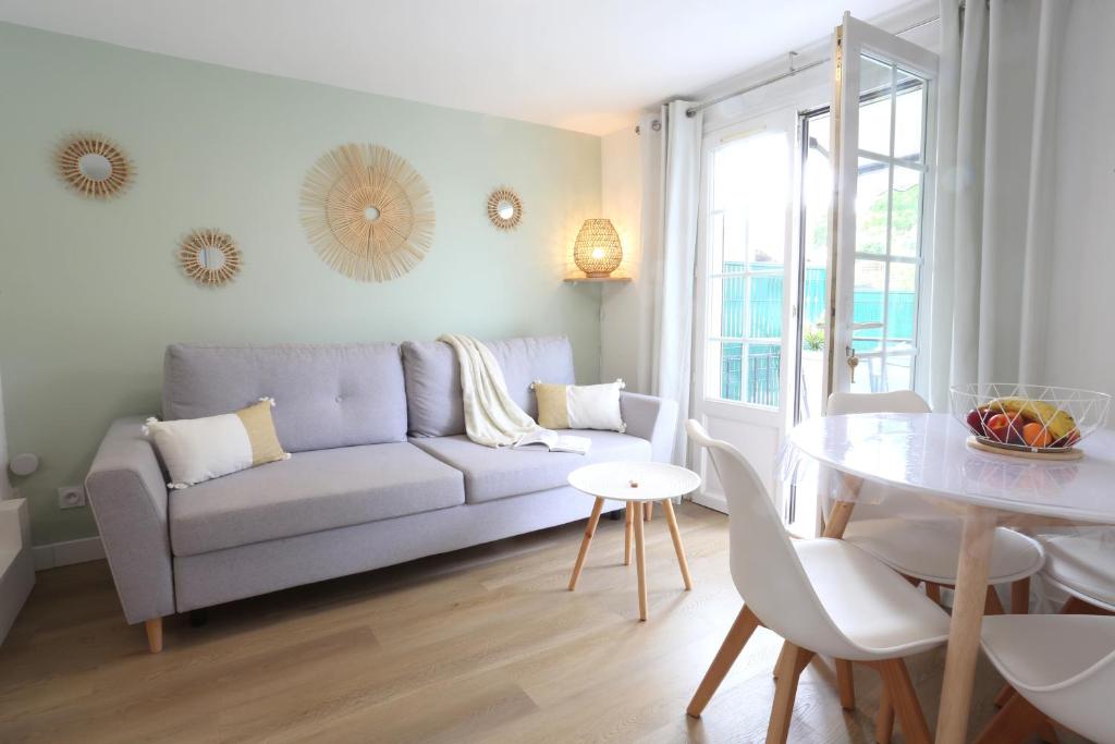 a living room with a couch and a table at T2 avec terrasse / 10mn grande plage in Royan