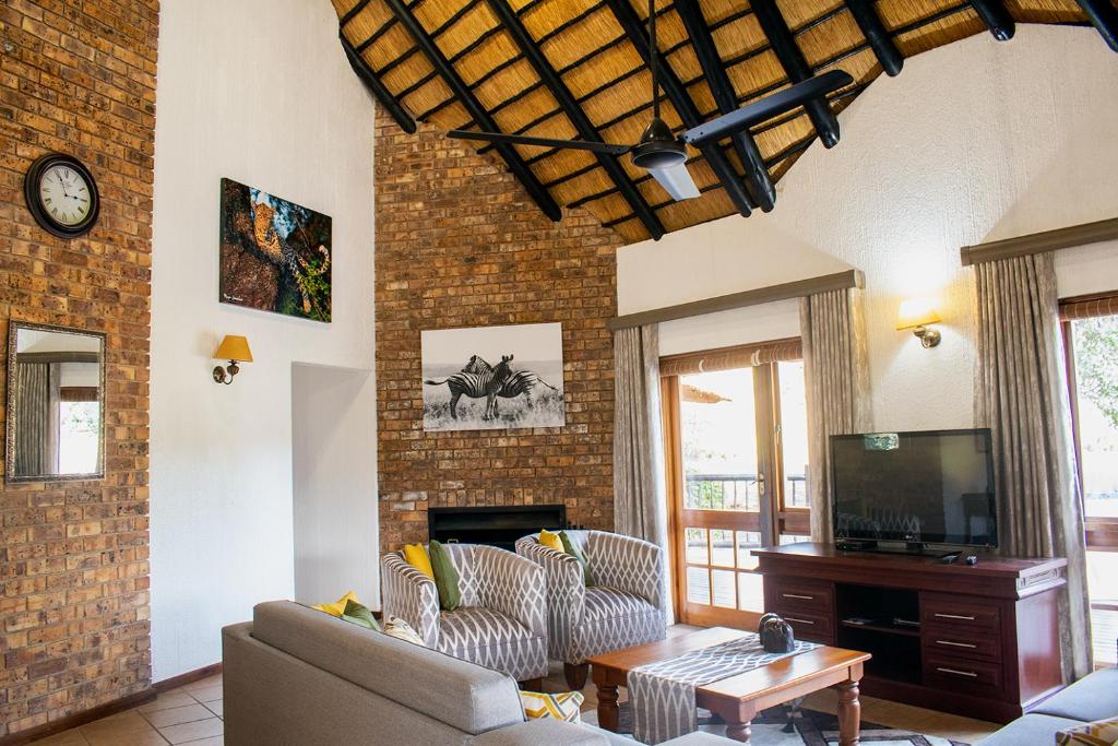 a living room with a couch and a tv at Kruger Park Lodge Unit 245 in Hazyview