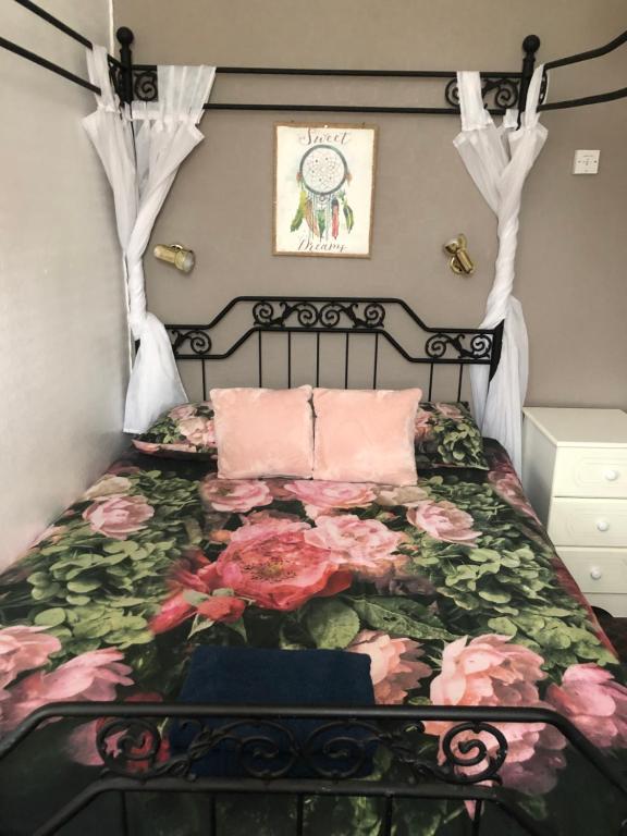 a bedroom with a bed with pink flowers on it at Melrose Hotel in Blackpool