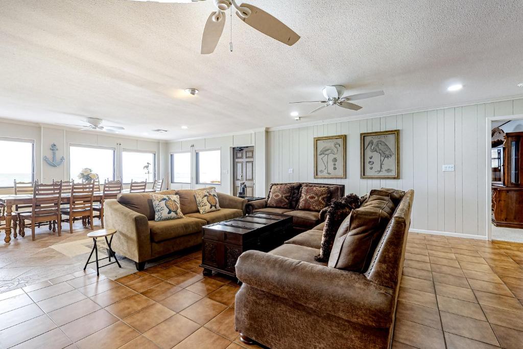 a living room with two couches and a table at Anchors Away at North Shore in Port Isabel