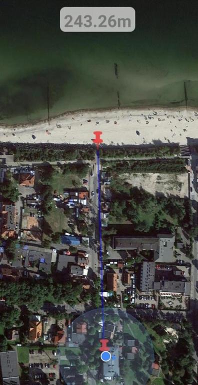 an aerial view of a beach with a red cross at Apartament Sea Planet Mielno Centrum - parking w cenie pobytu in Mielno