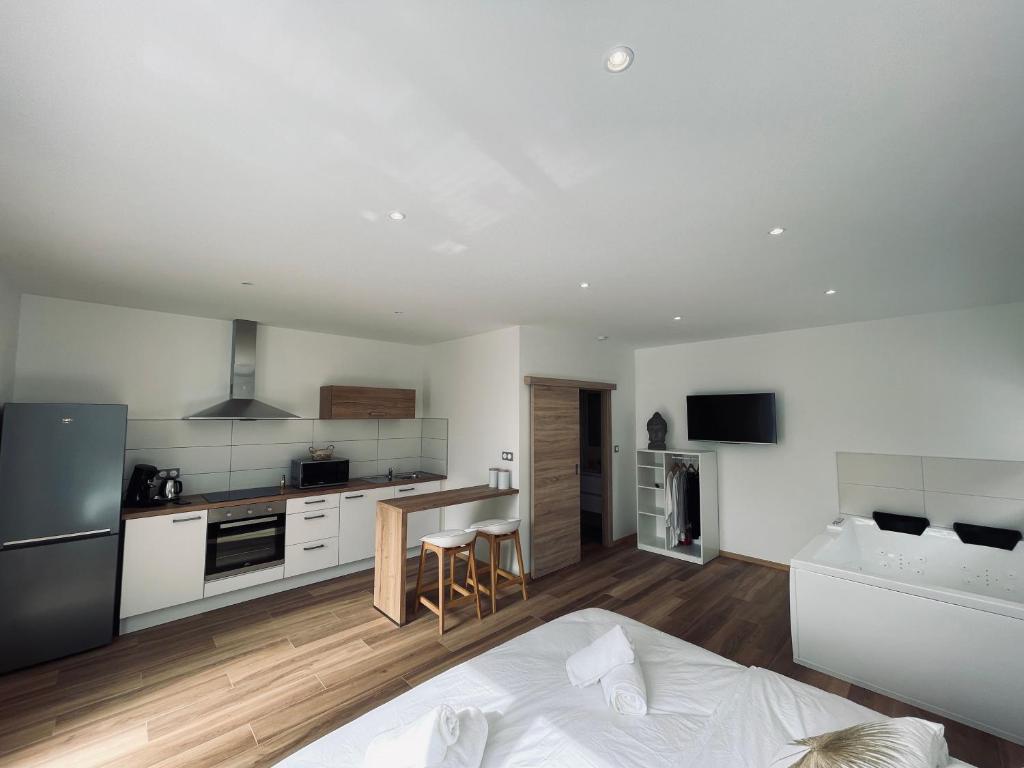 a white kitchen with a bed in a room at Studio Balnéothérapie in Wintzenheim