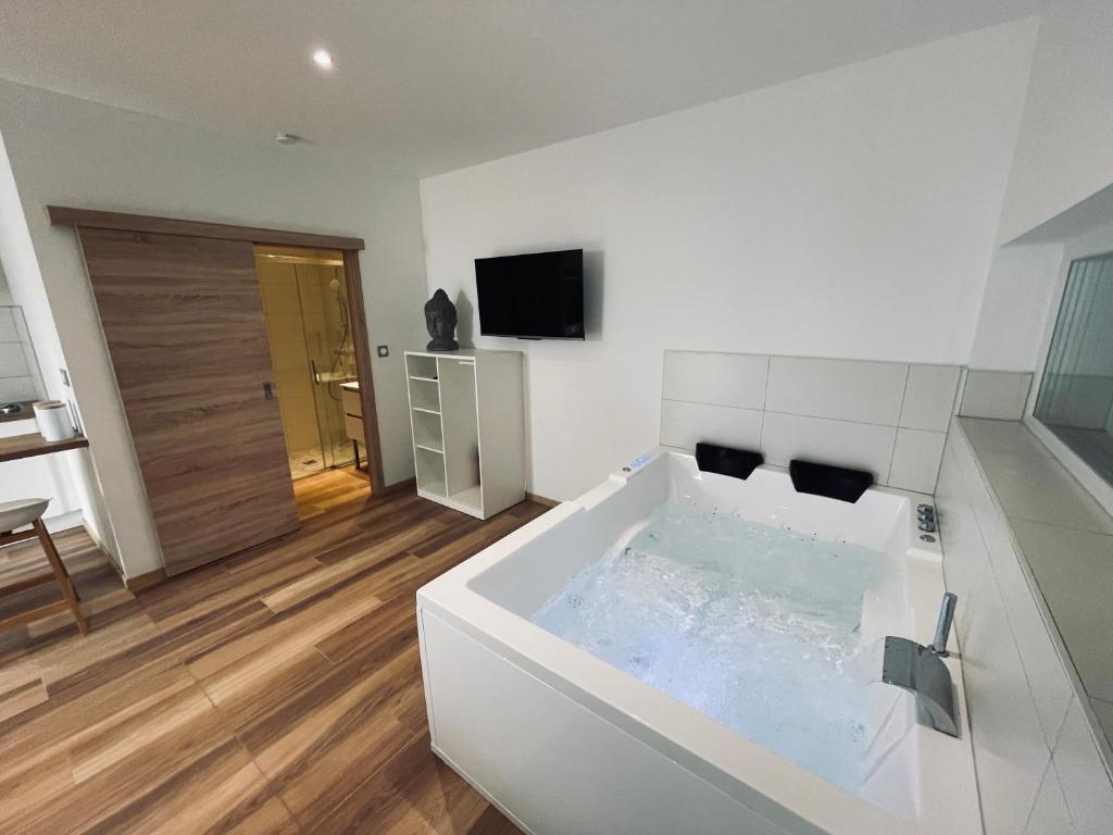 a large white bath tub in a room at Studio Balnéothérapie in Wintzenheim