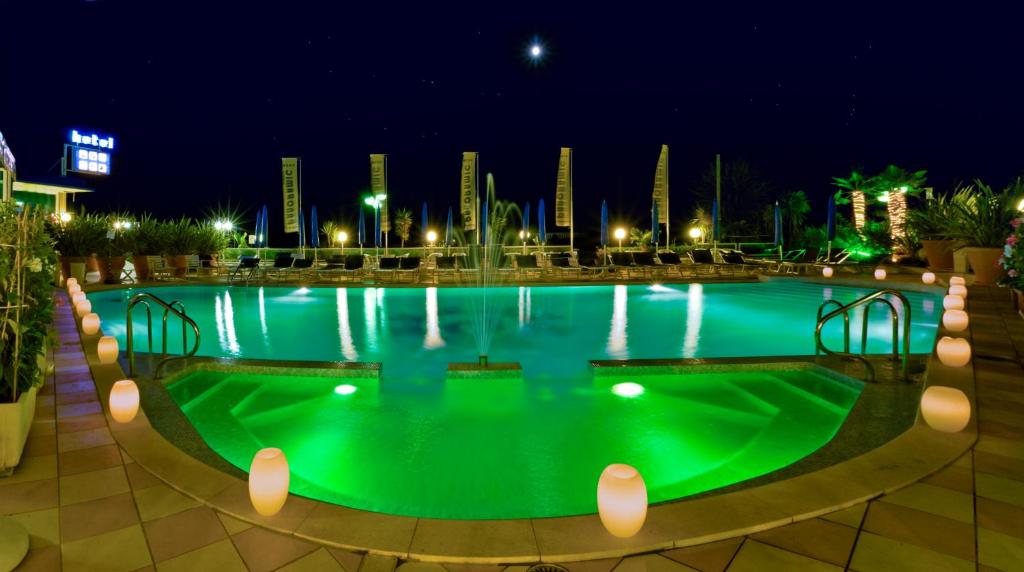 duży basen z zieloną wodą w nocy w obiekcie Hotel Panoramic w Caorle