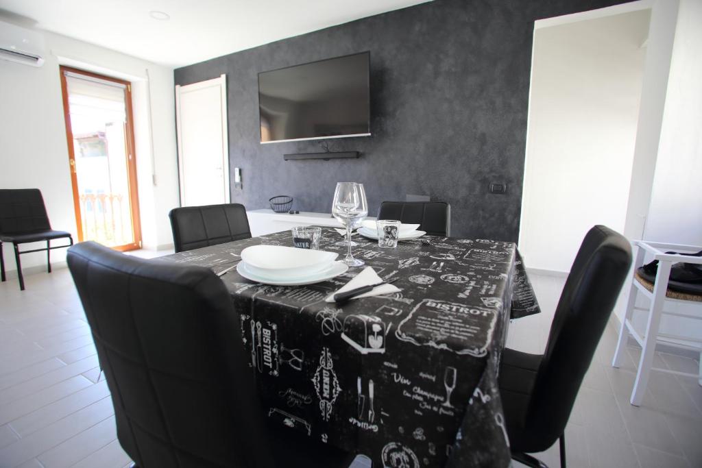 uma mesa de jantar com uma toalha de mesa preta e branca em Sweet C&C em Calangianus