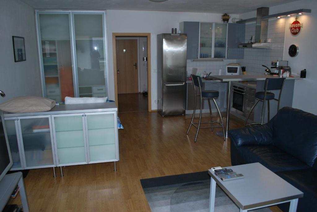 a living room with a couch and a kitchen at Chotěšovská Apartment with Parking Place in Prague