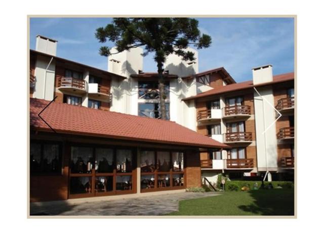 a large building with a tree in front of it at Condominio Residencial pousada do Serran0 in Gramado