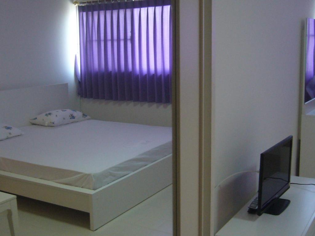 1 dormitorio con 1 cama con ventana y espejo en IMPACT Don Mueang Bangkok Guest House, en Nonthaburi