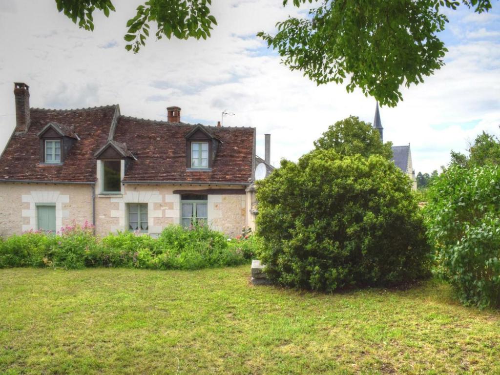 an old house in a yard with a tree at Gîte Montrésor, 4 pièces, 7 personnes - FR-1-381-72 in Montrésor