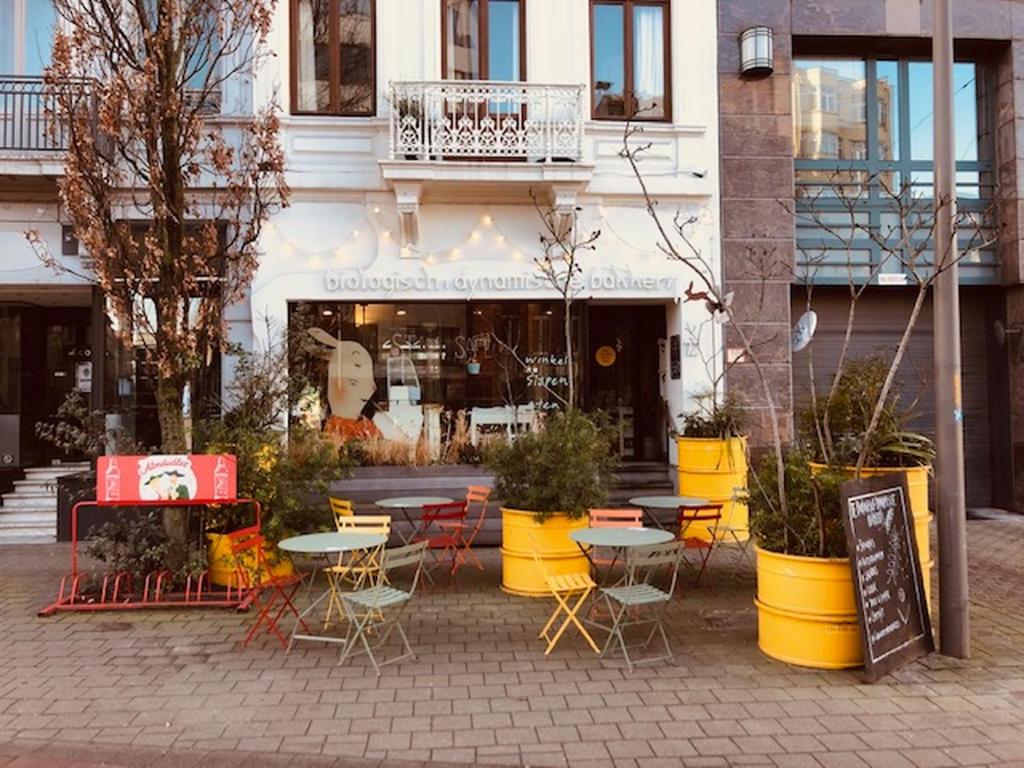 een groep tafels en stoelen voor een gebouw bij Logies Lapin in Antwerpen