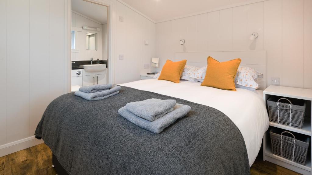 a bedroom with a large bed with towels on it at Tayview Lodges in Dunkeld
