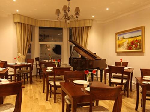a restaurant with tables and chairs and a piano at The Redstone Guesthouse in Blackpool