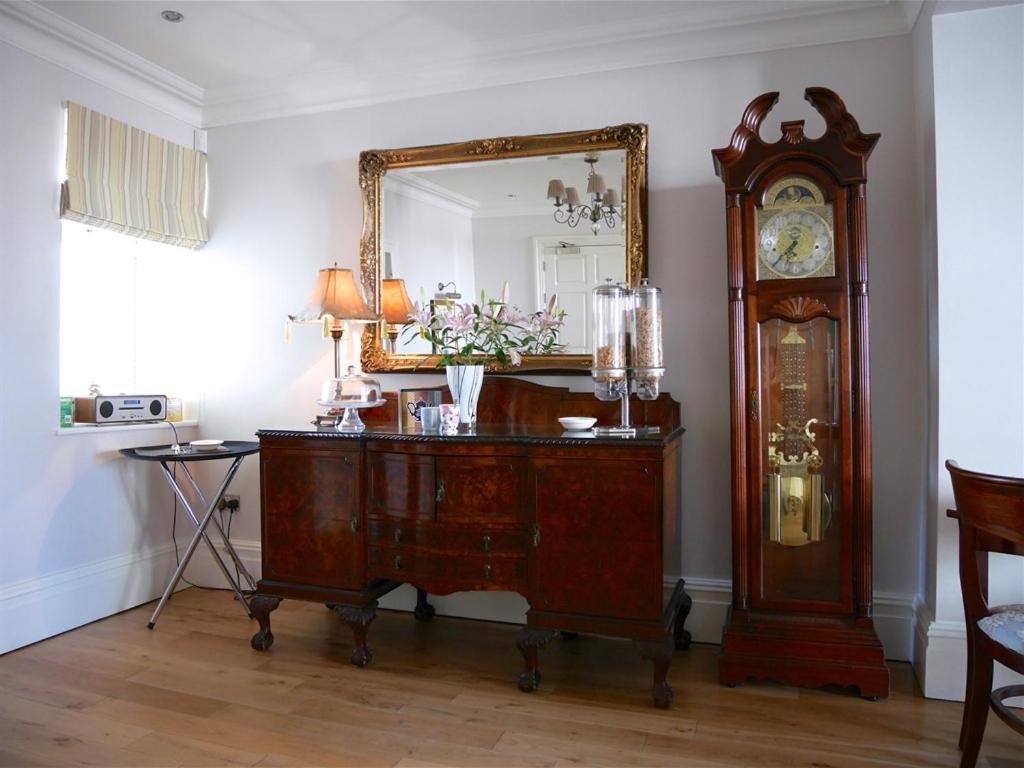 a room with a grandfather clock and a mirror at The Redstone Guesthouse in Blackpool