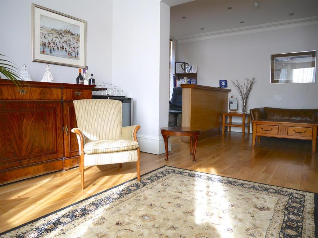 a living room with a chair and a table at The Redstone Guesthouse in Blackpool