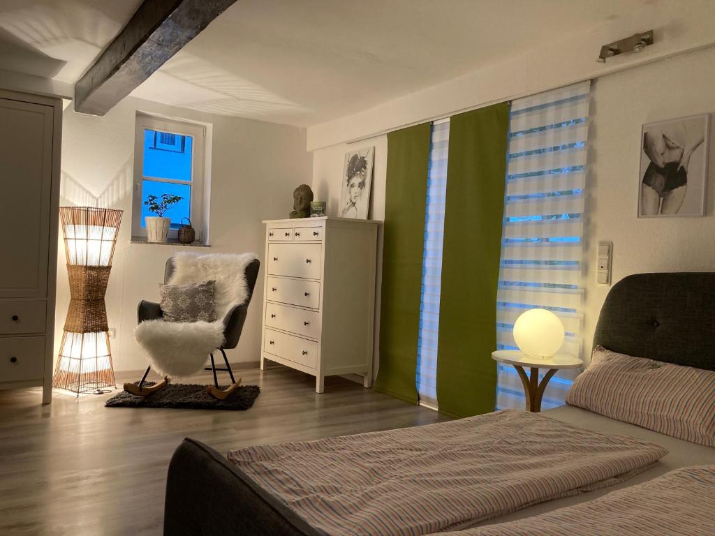 ein Schlafzimmer mit einem Bett, einem Stuhl und einer Kommode in der Unterkunft Ferienwohnung schöner Rheingau in Bad Schwalbach