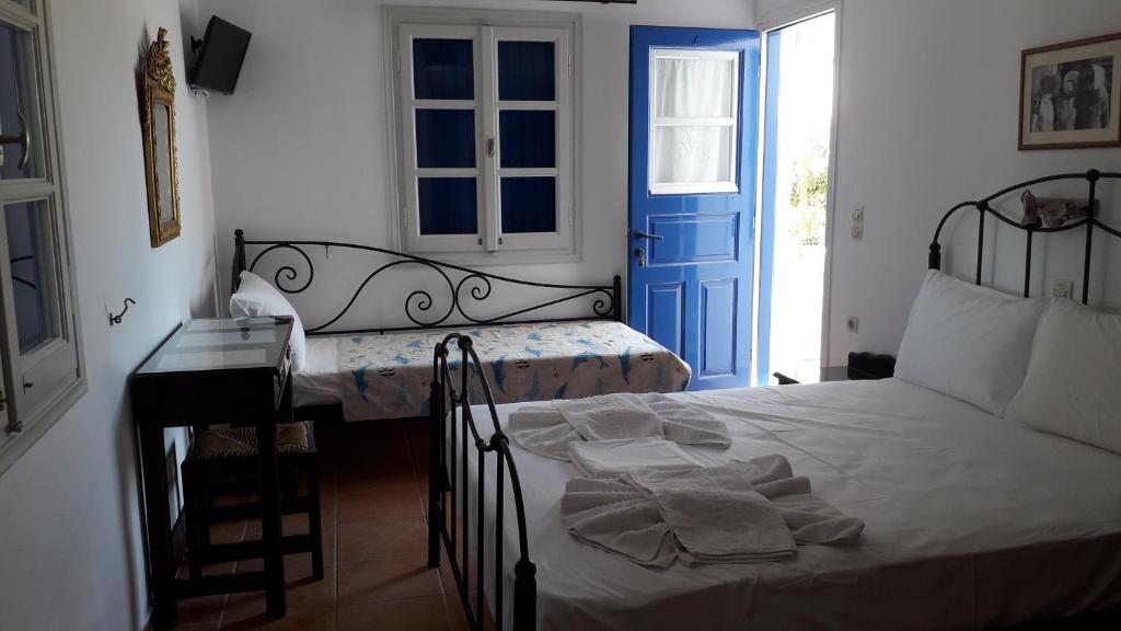 1 dormitorio con 1 cama y puerta azul en anerousa, en Loutra