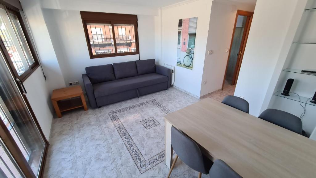 een woonkamer met een bank en een tafel bij piso a 2 minutos de la playa in Valencia