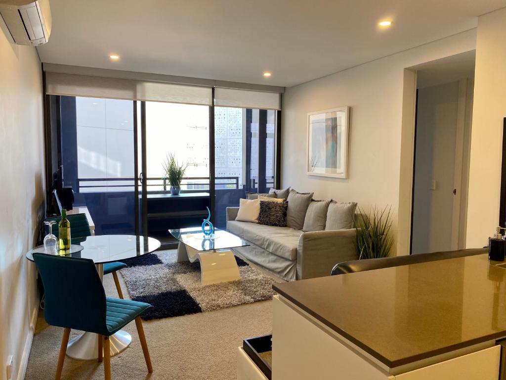 a living room with a couch and a table at Governor Luxe 1 BR Apartment in the heart of Barton WiFi Gym Wine Secure Parking Canberra in Kingston 