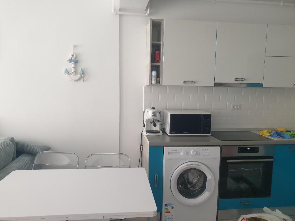 eine Küche mit einer Waschmaschine und einer Waschmaschine in der Unterkunft Blue apartament in Mamaia