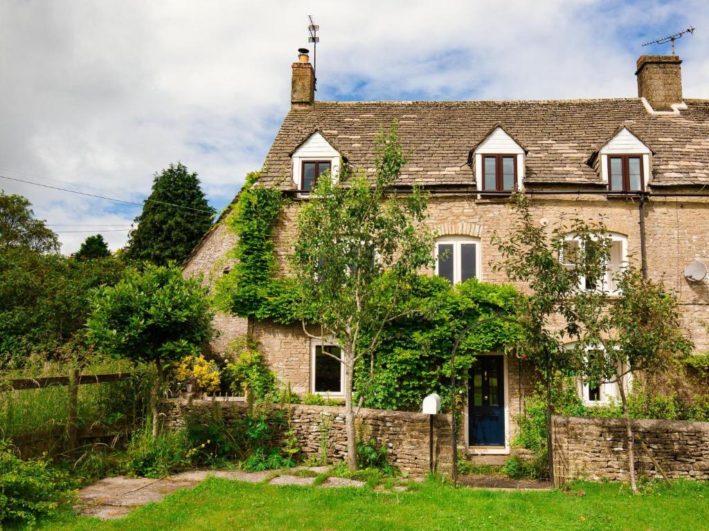 an old stone house with ivy on it at Field View in Cirencester