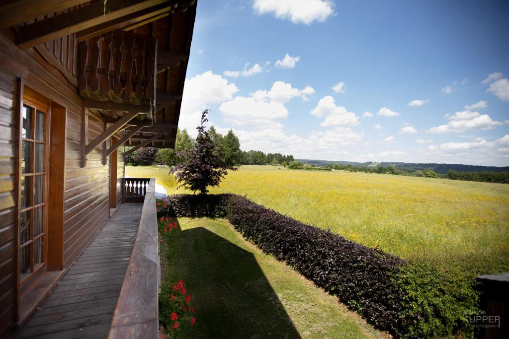 a porch of a house with a view of a field at Le Gagnage 31 pers- Malmedy, rustique, vue, wellness in Malmedy