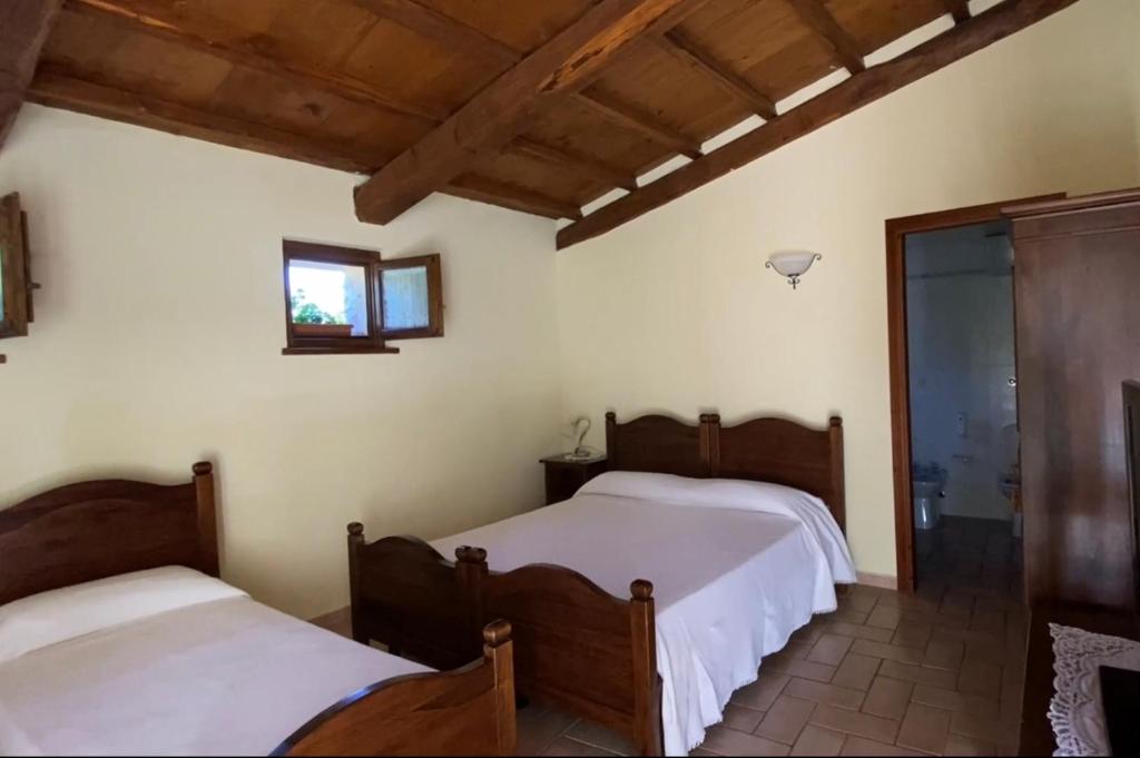1 Schlafzimmer mit 2 Betten und einem Fenster in der Unterkunft Locanda Cacio Re in Vallo di Nera