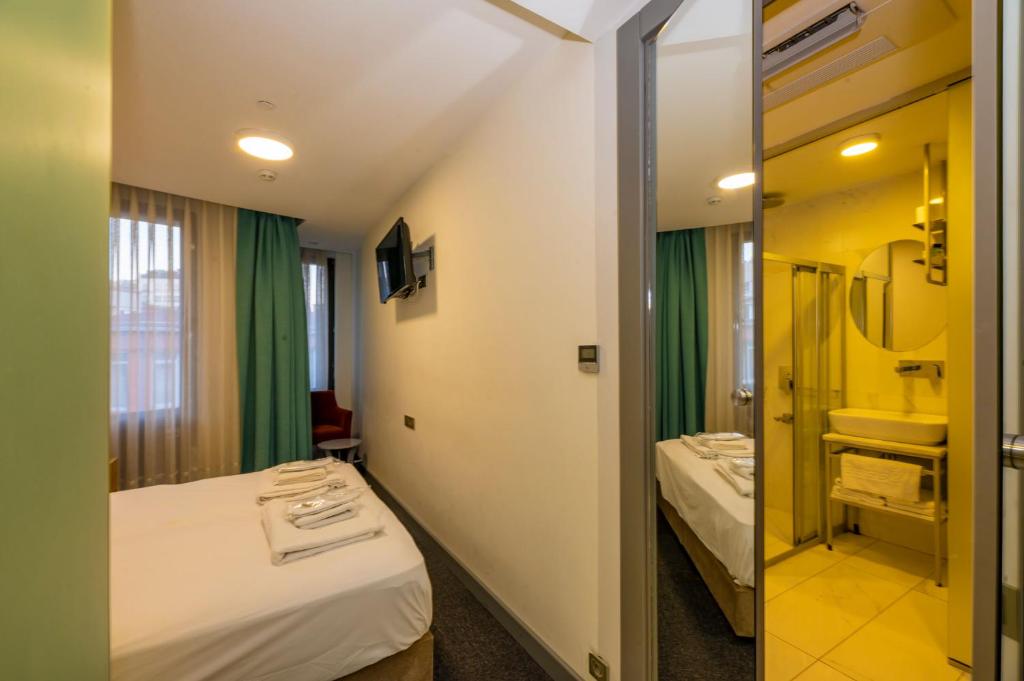 A bed or beds in a room at Taksim Hotel V Plus