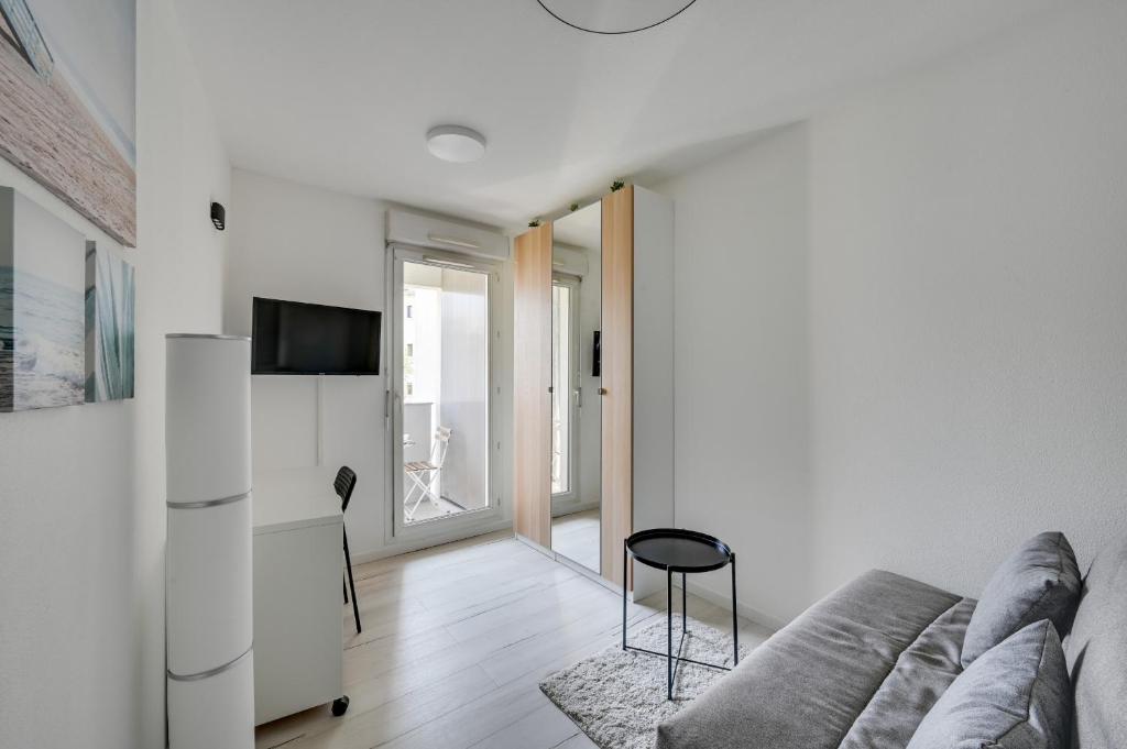 a living room with a couch and a tv at DIFY Splendide - Jean Mace in Lyon
