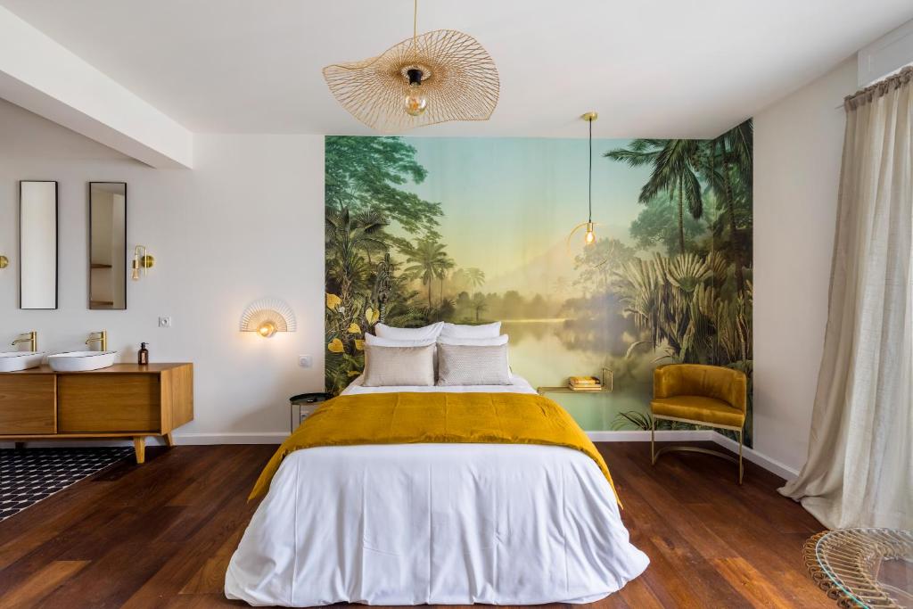 - une chambre avec un lit et une peinture murale dans l'établissement Libertitu, à Bayonne