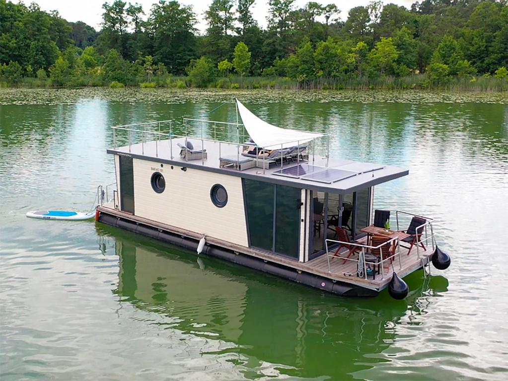 un pequeño barco sentado en medio de un lago en Hausboot La Mesa, en Lychen