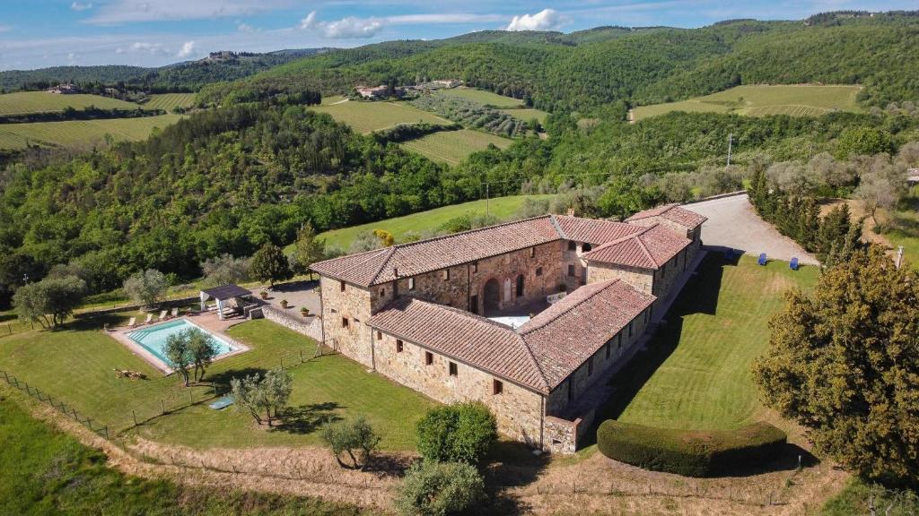 uma vista aérea de uma grande casa de pedra com uma piscina em Villa La Corte Di Campalli em Castellina in Chianti