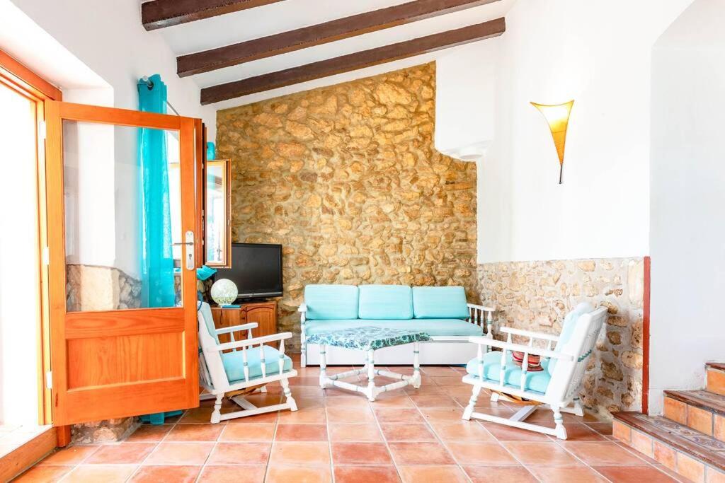 uma sala de estar com um sofá e duas cadeiras em Villa Mosteiro, 'The Cosy Corner' em Santa Margalida