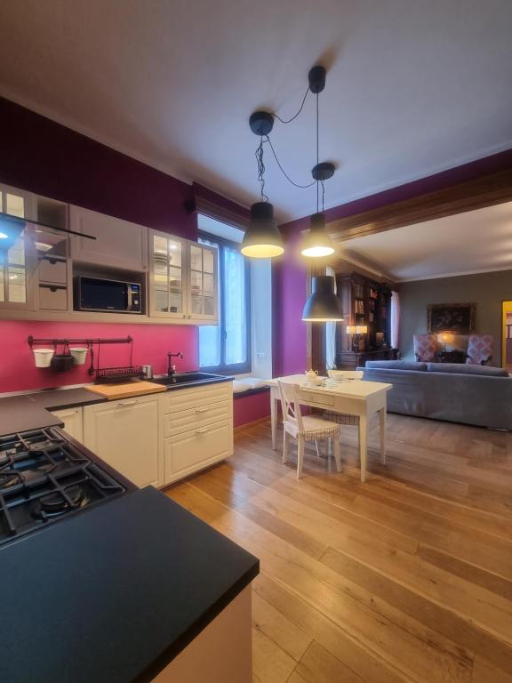 a kitchen and living room with a table and a dining room at L'Atelier du Temps - SUENDESUA' Appartement in Aosta