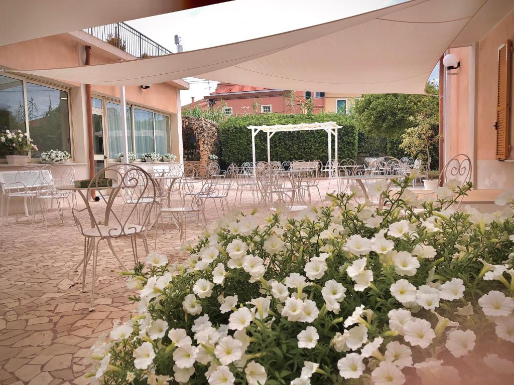 ピエトラ・リーグレにあるHotel Villa Paolinaの白い花が咲き誇るパティオ