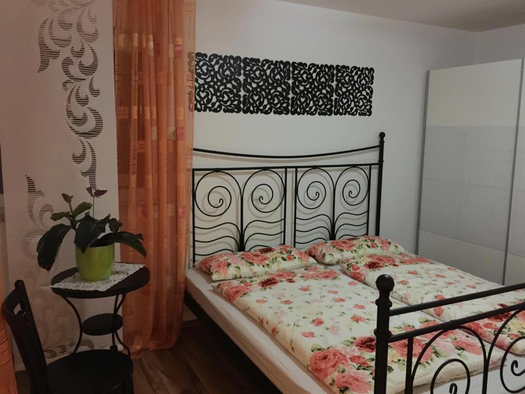 a bedroom with a black bed with a floral bedspread at Ferienwohnung Viktoria in Bad Kissingen