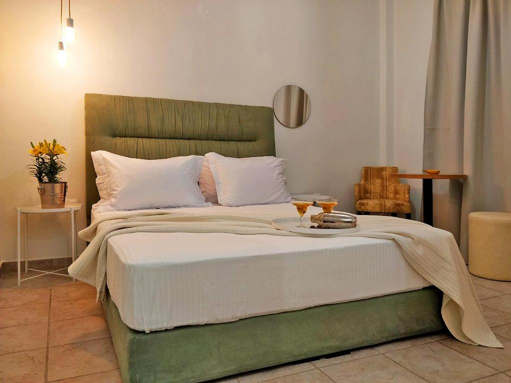 a bedroom with a green bed with two drinks on it at Sivilla Budget Studios in Afitos