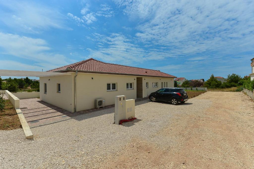 dom z samochodem zaparkowanym przed nim w obiekcie Villa Manuela with heated pool 400 meters from the sea - by TA Leut Agency w mieście Vrsi