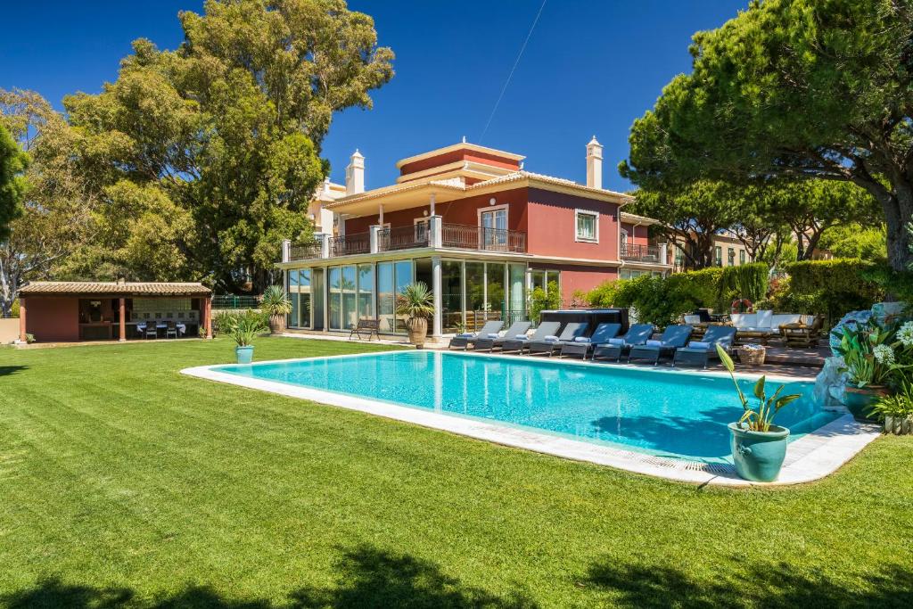 a house with a swimming pool in front of a yard at Vila Santa Eulália in Albufeira