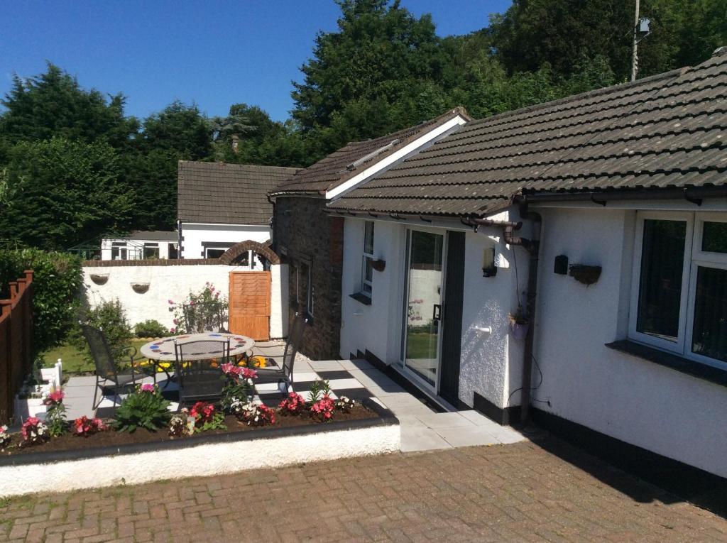 Casa con patio con mesa y flores en Charming 3-Bed Cottage Exmoor near Barnstaple, en Barnstaple