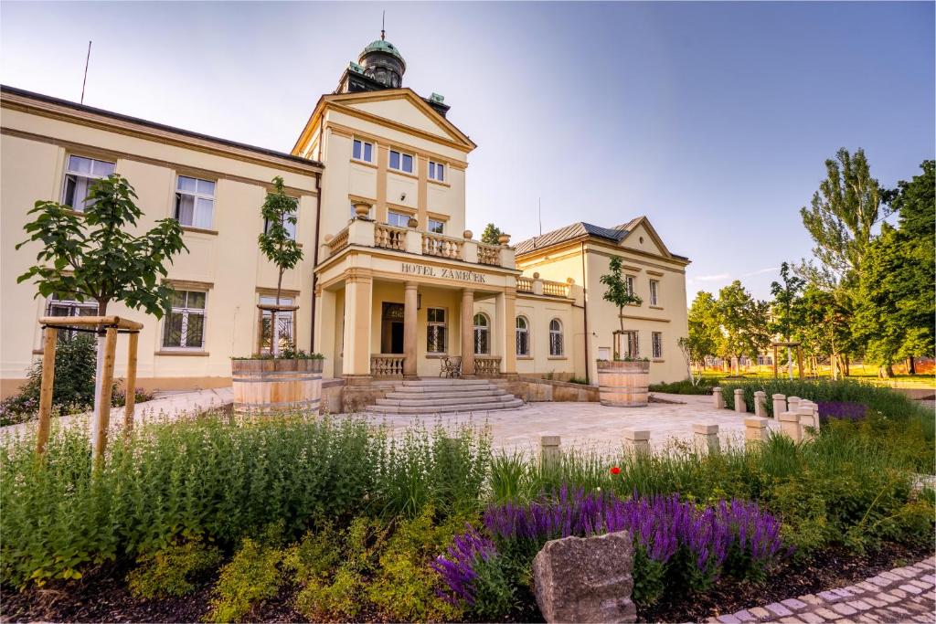 un ancien bâtiment avec un jardin en face de celui-ci dans l'établissement Hotel Zámeček, à Poděbrady