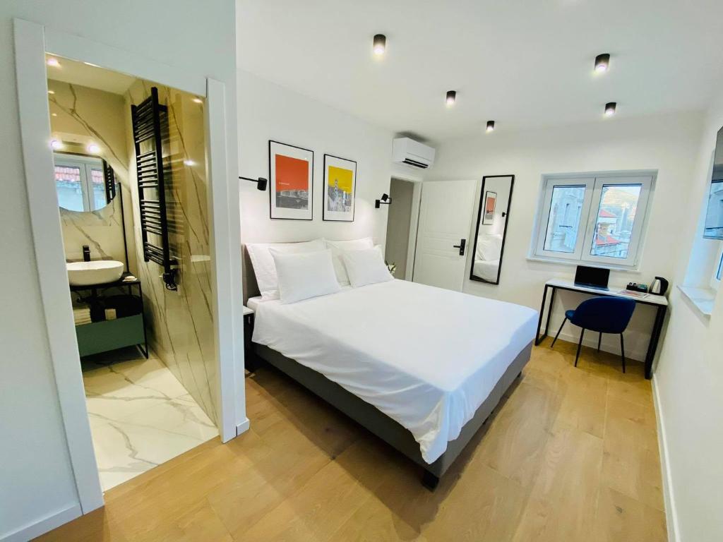 a bedroom with a large white bed and a bathroom at Luxury TownHouse Baba in Dubrovnik