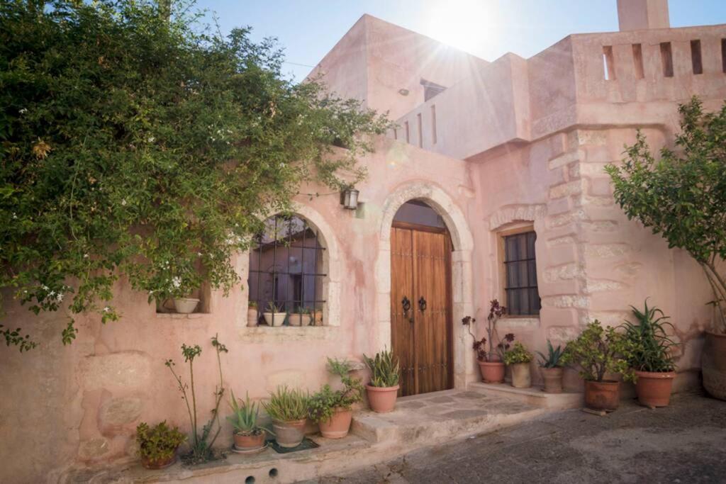 Káto KhoríonにあるNino's house - in kato chorio of Ierapetraの木の扉と鉢植えの植物が並ぶ家